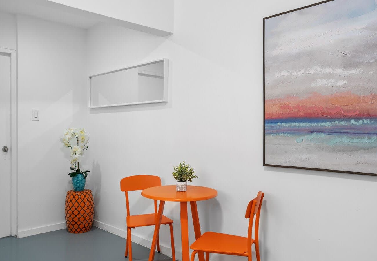 Sunny bistro table with ocean-sunset art