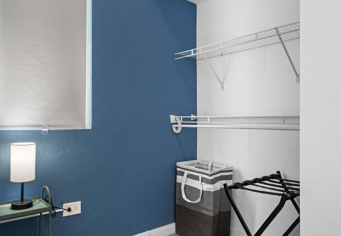 Open closet with shelves, hamper & luggage rack