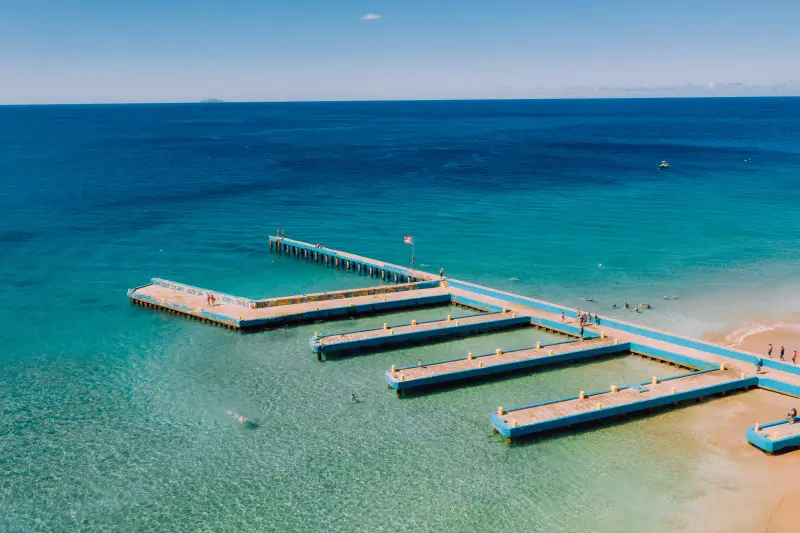 Dive into the refreshing turquoise water, feel the silky-soft sand between your toes, and savor delicious treats from the nearby kiosks. This world-famous beach offers an unforgettable experience.