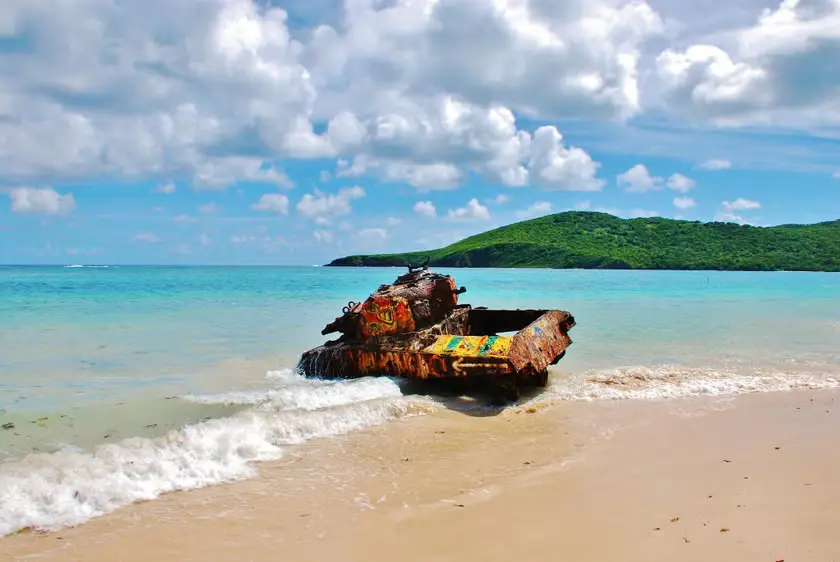 A stunning tropical beach with white sand, turquoise waters, and a clear blue sky.