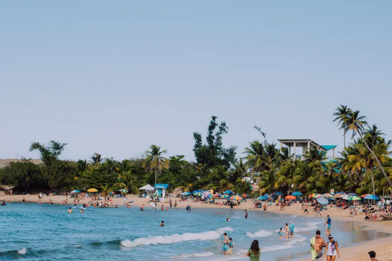 The beach itself is a beautiful stretch of golden sand, contrasting with the clear blue waters. Surfers will find challenging waves, while families can enjoy calmer areas for swimming and sunbathing.  