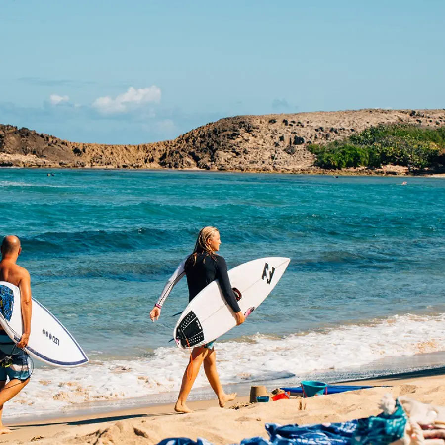 The beach itself is a beautiful stretch of golden sand, contrasting with the clear blue waters. Surfers will find challenging waves, while families can enjoy calmer areas for swimming and sunbathing.  