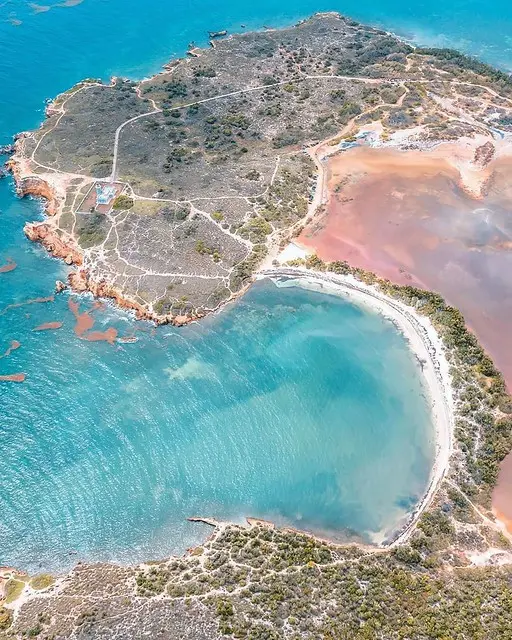 A stunning beach with clear turquoise waters and a pristine, light-colored sandy shoreline.